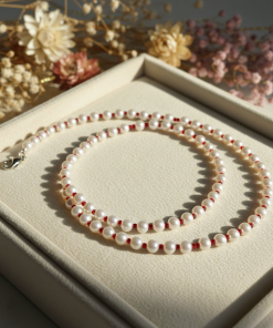 Candy cane necklace of pearls and small red beads.