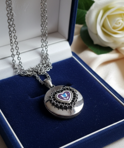Vintage silver-tone heart locket with an engraved tulip motif, a classic floral-themed picture locket necklace.